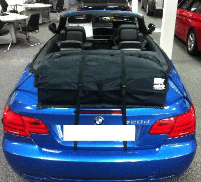 blue bmw e93 convertible with the roof down and a boot-bag vacation luggage rack fited