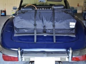 blue jagaur e type convertible with a boot-bag vacation luggage rack fitted photographed from behind