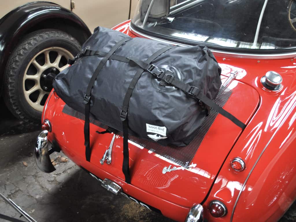 Red austin healey 3000 with a hard top fitted and a boot-bag luggage rack on the boot
