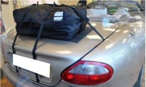 gold silver jaguar xk8 with a boot-bag original luggage rack fitted hood down in a classic car dealership