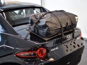 black mazda mx5 rf with a boot-bag original luggage rack fitted in a mazda showroom