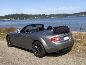 silver mazda mx5 miata prht roadstr coupe next to a lake with a boot-bag boot trunk rack fitted next to a lake