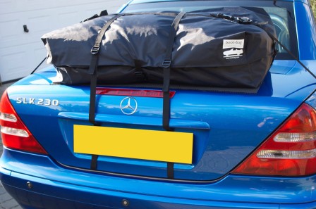 blue slk r230 mk1 with a boot-bag vacation luggage rack fitted on a drive next to a garage