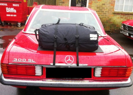 red mercedes-benz 300sl with a boot-bag luggage rack fitted
