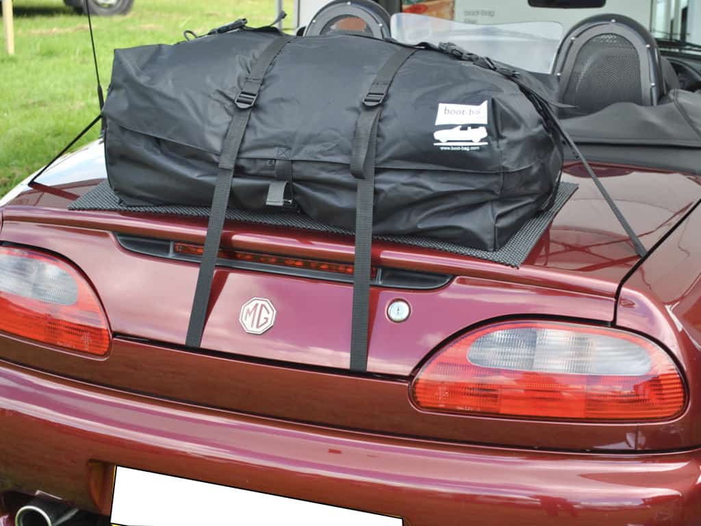 close up of a luggage rack fitted to a burgundy mgtf with the hood down