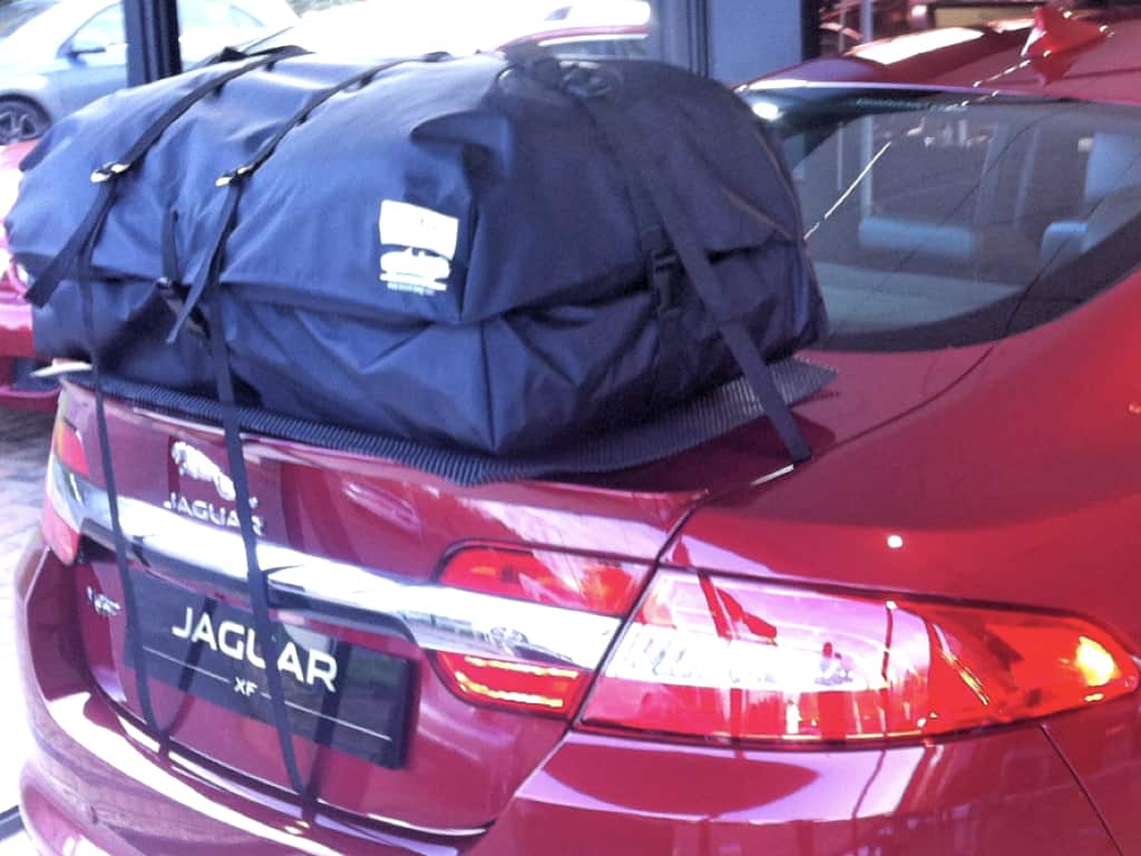rear view of a Jaguar xf with a roof box fitted in a jaguar garage