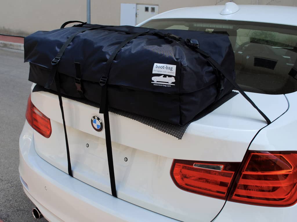 white bmw 3 series saloon with a roof box fitted