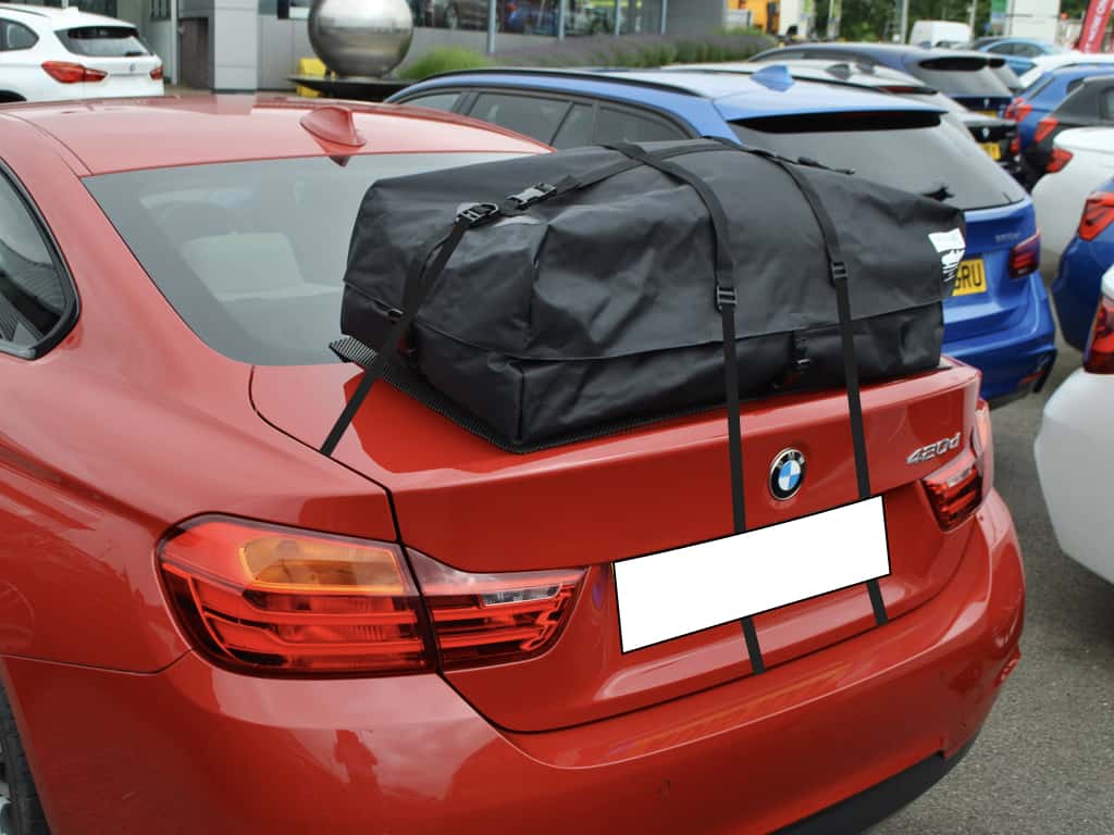 red bmw 4 series coupe 420d outside bmw oxford with a boot-bag vacation roof box fitted