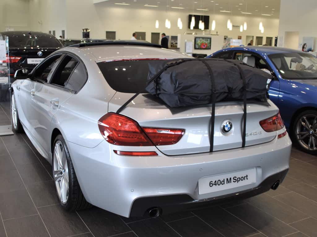silver bmw 6 series coupe in a bmw garage with a roof box fitted