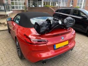 orange bmw z4 g29 m40i with a luggage rack fitted carrying a set of gold clubs in a car park