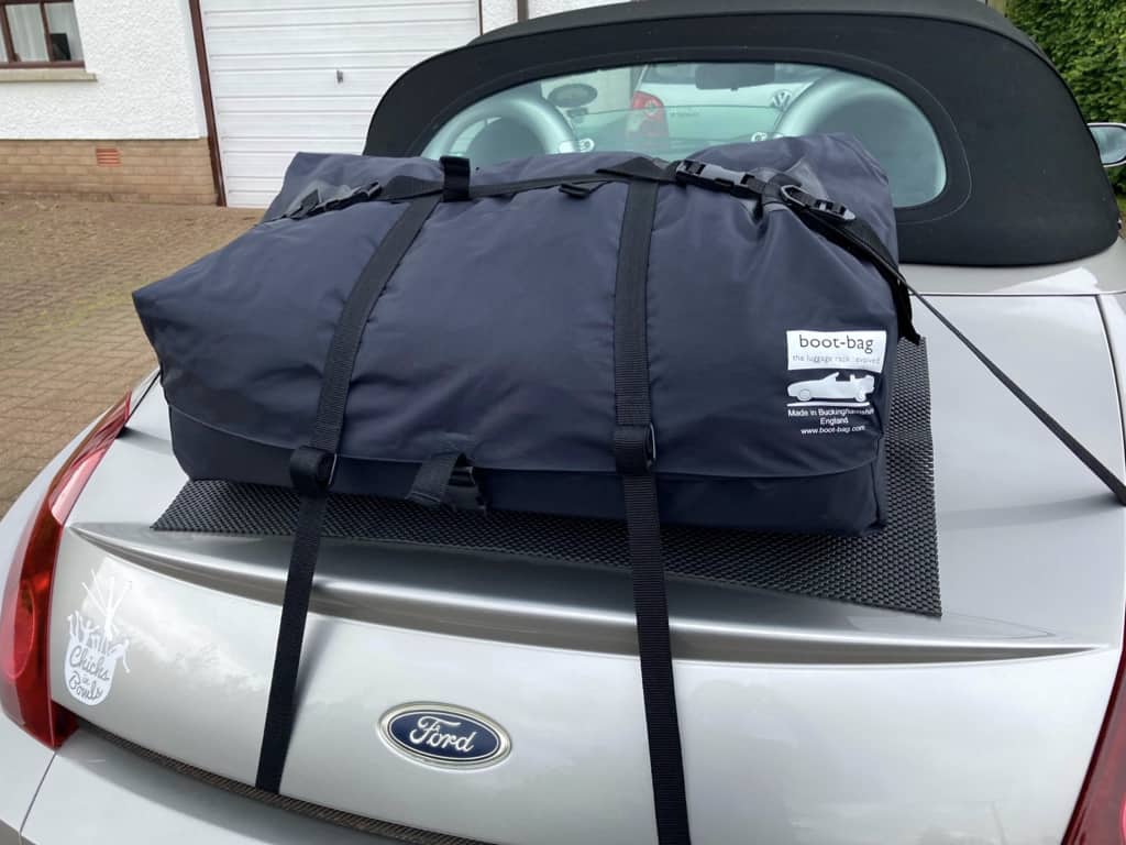 silver ford street ka convertible on a driveway with a boot-bag luggage rack fitted photographed from the rear.