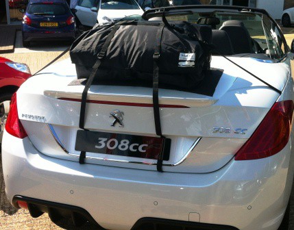 white peugeot 308cc with a luggage rack fitted photographed from behind