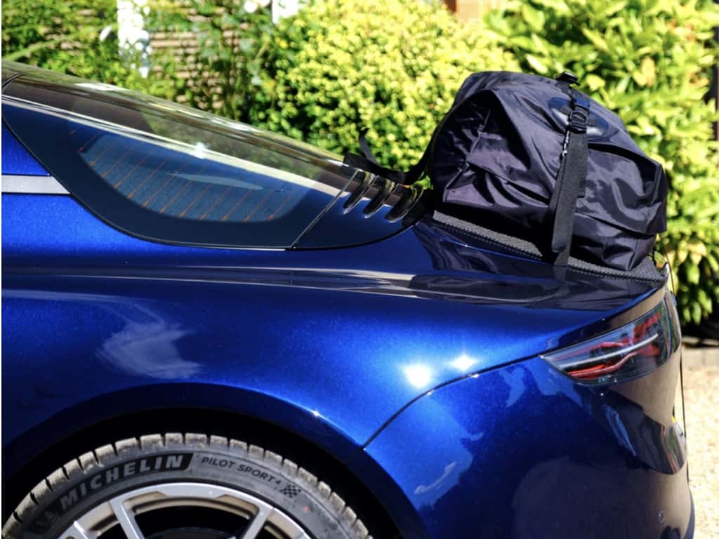 side view of a blue alpine a110 with a boot-bag luggage rack bag fitted
