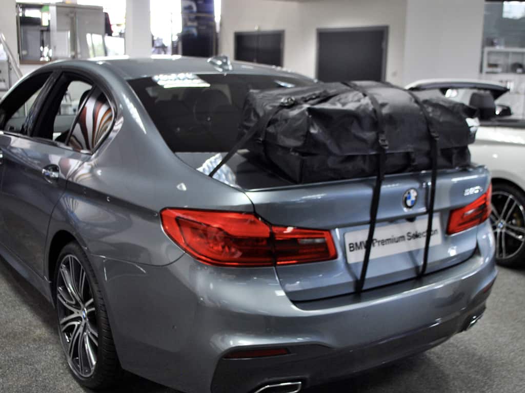rear view of a bmw 520d salon with a roof box fitted in a bmw showroom