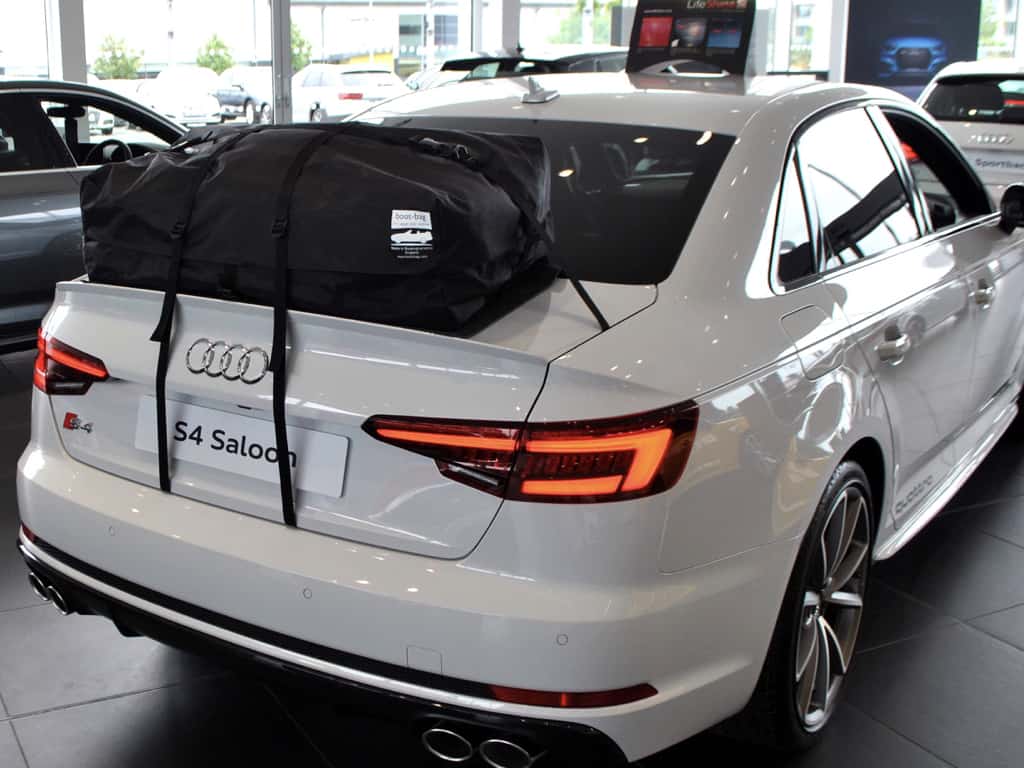 white audi a4 saloon with a boot-bag roof box fitted in an audi showroom