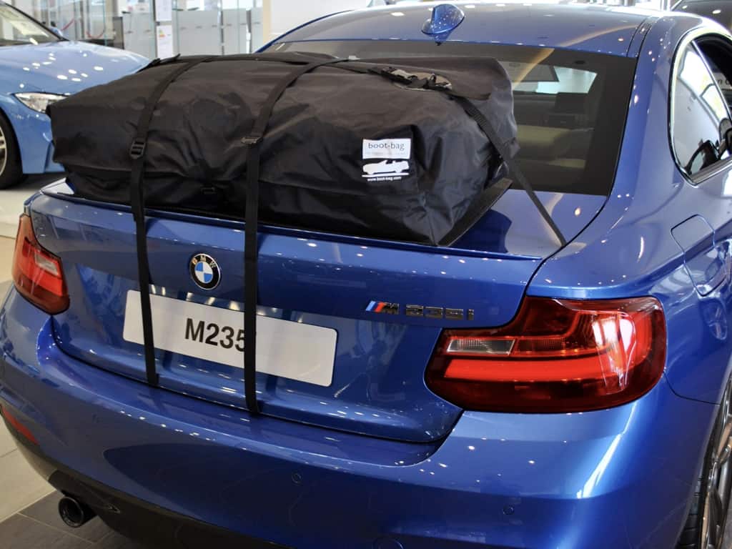 blue m235i bmw with a roof box fitted in a bmw garage