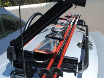 silver audi tt roadster avec un porte-bagages revo-rack équipé de porte-skis transportant des skis