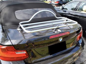 Zwarte BMW 2-serie cabriolet op een zonnige dag met een bagagerek gemonteerd