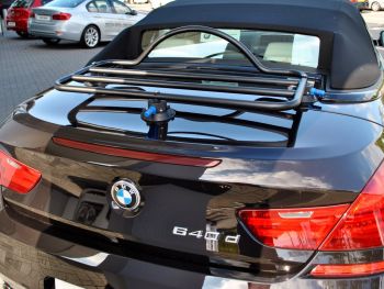 zwarte BMW 6-serie cabrio buiten een BMW-garage met een revo-rack bagagerek gemonteerd