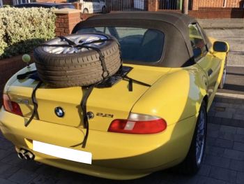 BMW Z3 amarillo con un soporte para rueda de repuesto de emergencia montado en la tapa del maletero con una rueda