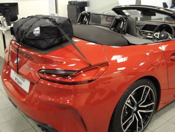 rode bmw z4 G29 M40i  in een BMW-showroom met het dak naar beneden en een bagagerek gemonteerd van achteren gefotografeerd