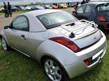 silver ford convertible street ka with a stainless steel luggage rack fitted at a car show on a sunny day