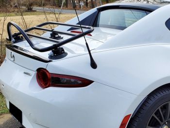white mazda mx5 rf with a luggage rack fitted to the trunk lid, the trunk has a spoiler and sirius antenna on it