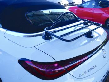 white mercedes cle convertible in a car park with a black luggage rack fitted to the trunk photographed close at the rear 