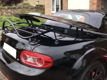 Black mazda mx5 folding metal roof roadster coupe with a revo-rack luggage rack fitted and the roof operating