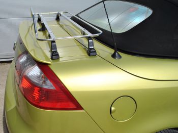 Side view of a yellow green saab 93 convertible with a stainless steel luggage rack fitted to the trunk