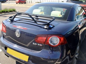 Volkswagen blu scuro vw eos in una giornata di sole con il tetto sollevato e il portapacchi nero montato sul bagagliaio / bagagliaio