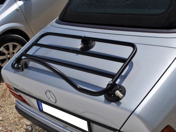 zilveren klassieke mercedes e klasse cabrio W124 buiten een mercedes-dealer met een zwart bagagerek gemonteerd