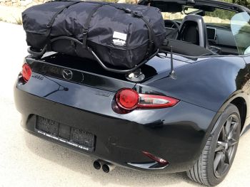 black mazda mx5 miata nd with a luggage rack fitted carrying a boot-bag waterproof luggage bag